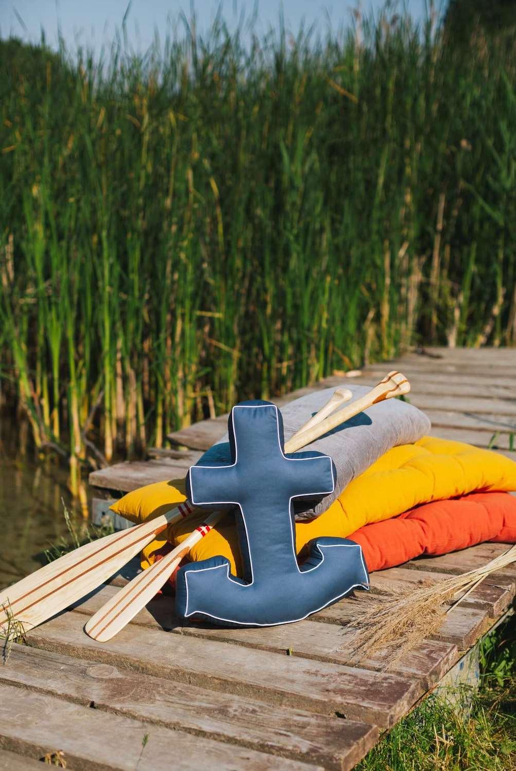 navy blue anchor cushion from bettys home stands on a lakeside pier 2