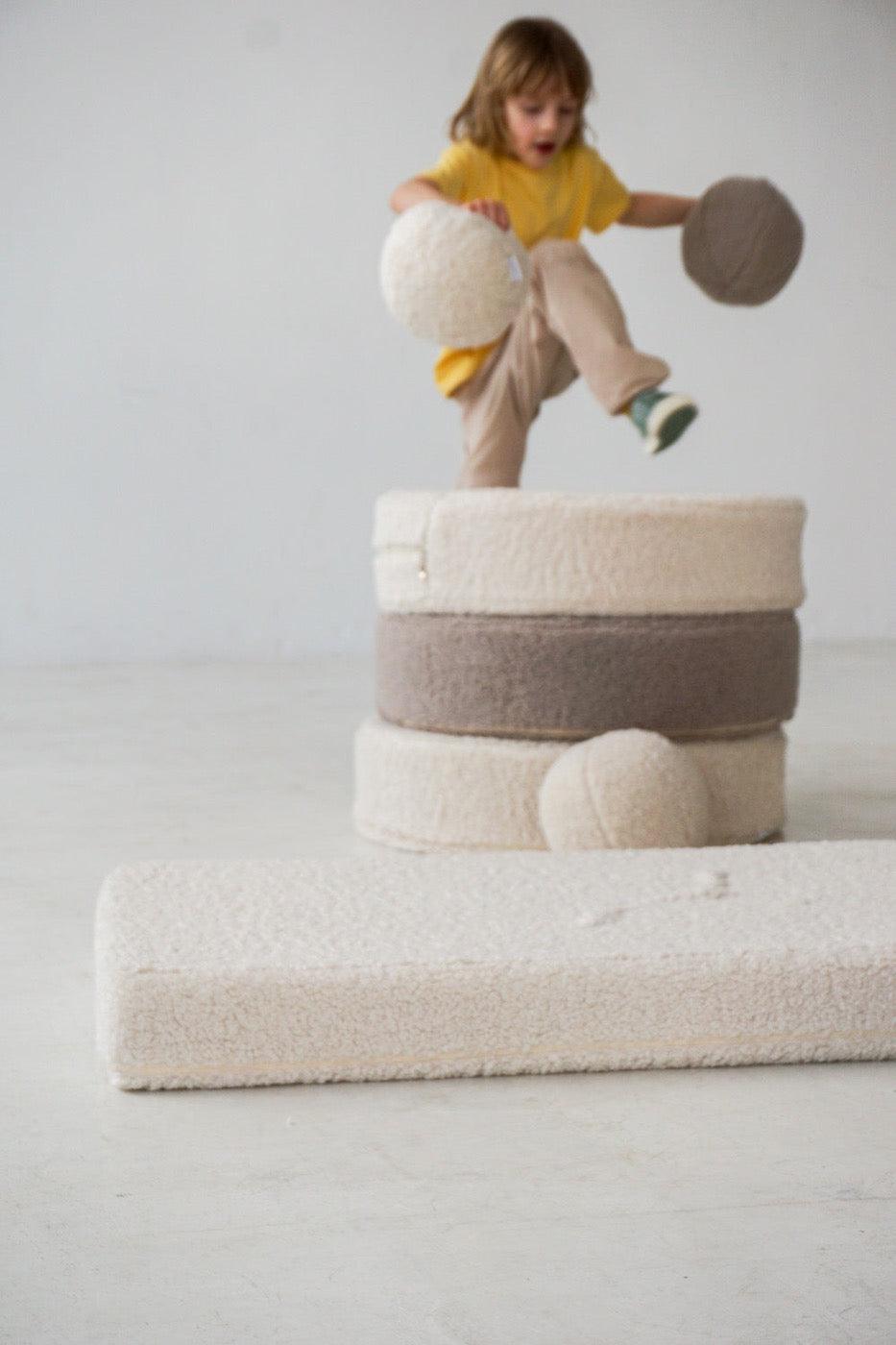 boy playing on boucle mattress and boucle pouf by bettys home with boucle ball, teddy boucle mattress for modern nursery