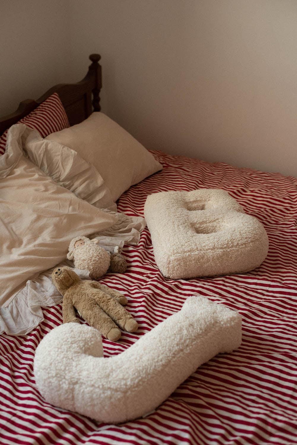 Boucle Letter cushion B and J by Bettys Home Teddy Letter Pillow lying on bed in bedroom as room decoration