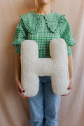 Boucle Letter cushion H by Bettys Home Teddy Letter Pillow held by woman in green checkered t-shirt