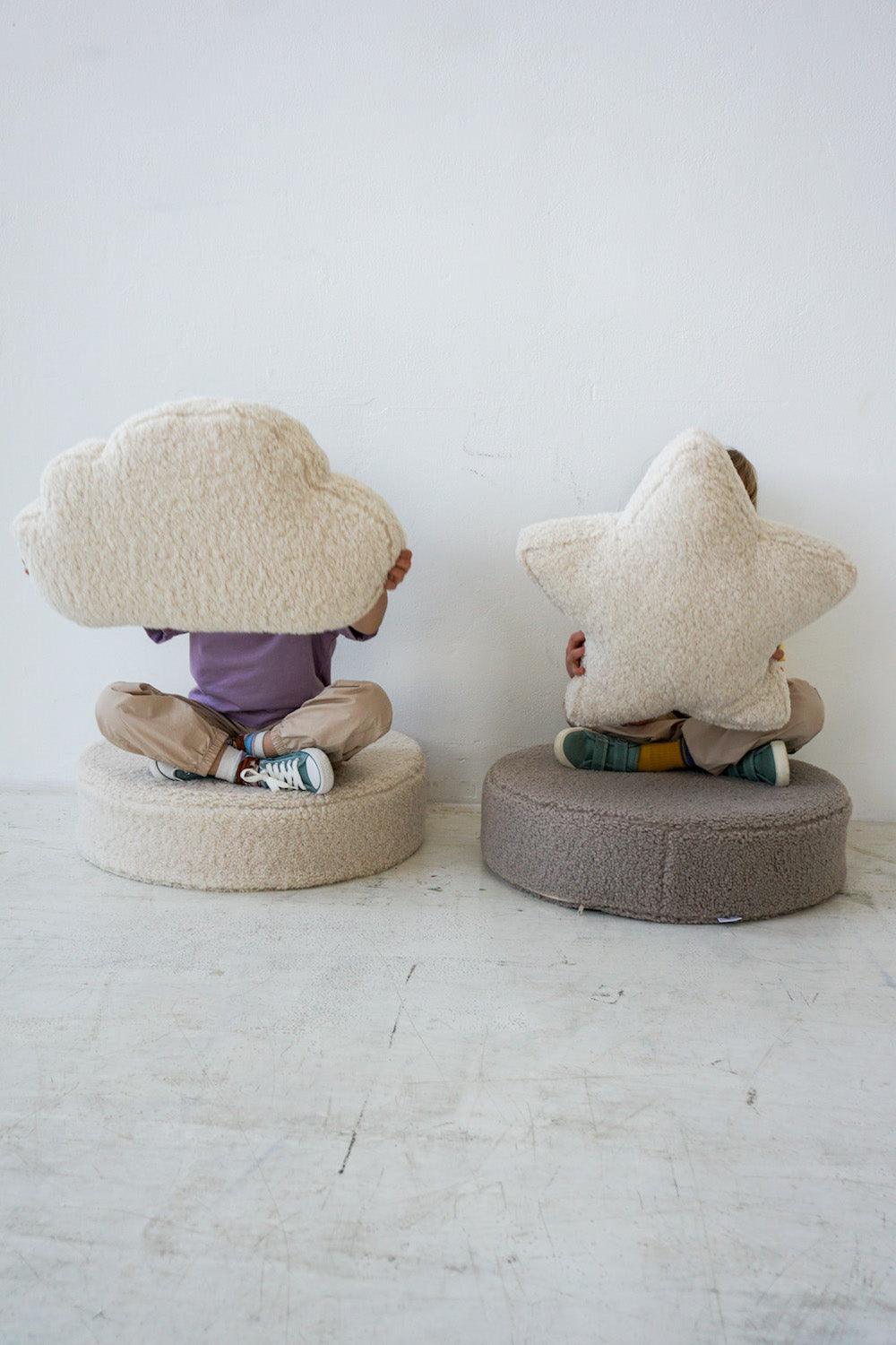 kids sitting on boucle floor poufs by bettys home with boucle cloud cushion and boucle star cushion in their hands