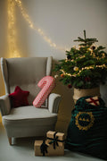 Christmas candy cane cushion red stripes by bettys home lying on an armchair next to the Christmas tree