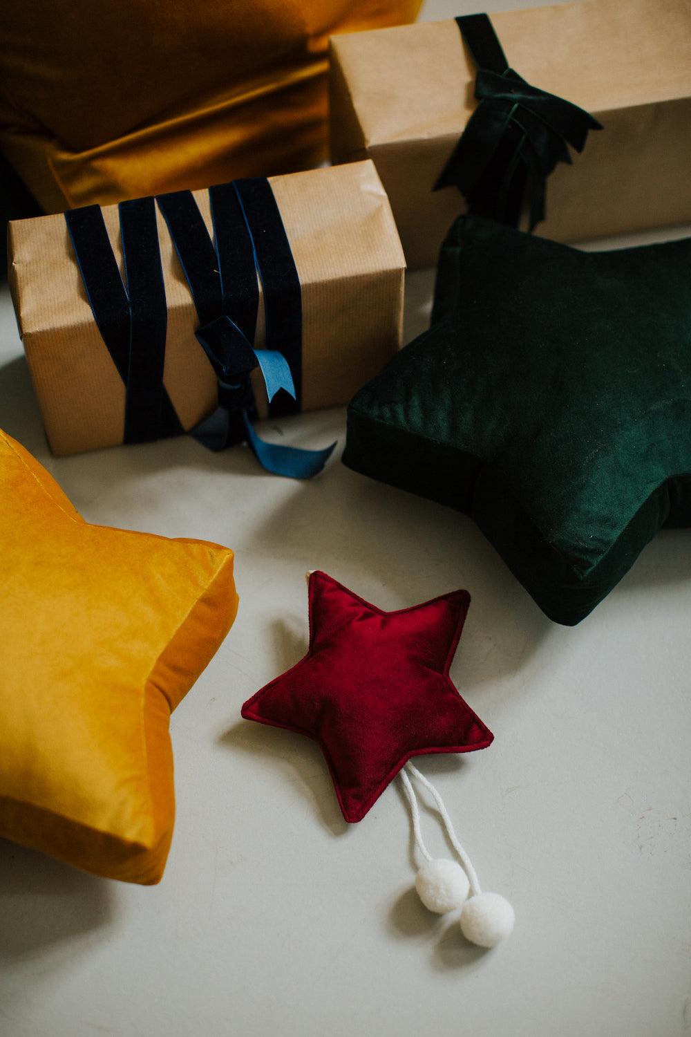 small star cushion yellow and green by bettys home next to gifts under christmas tree