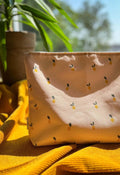 Cosmetic bag in lemons for the beach. Inside the cosmetic bag are children's wet bathing suits and sunscreen. Holiday essentials from Bettys Home