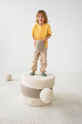 little boy standing on boucle large pouf by bettys home with boucle ball cushion