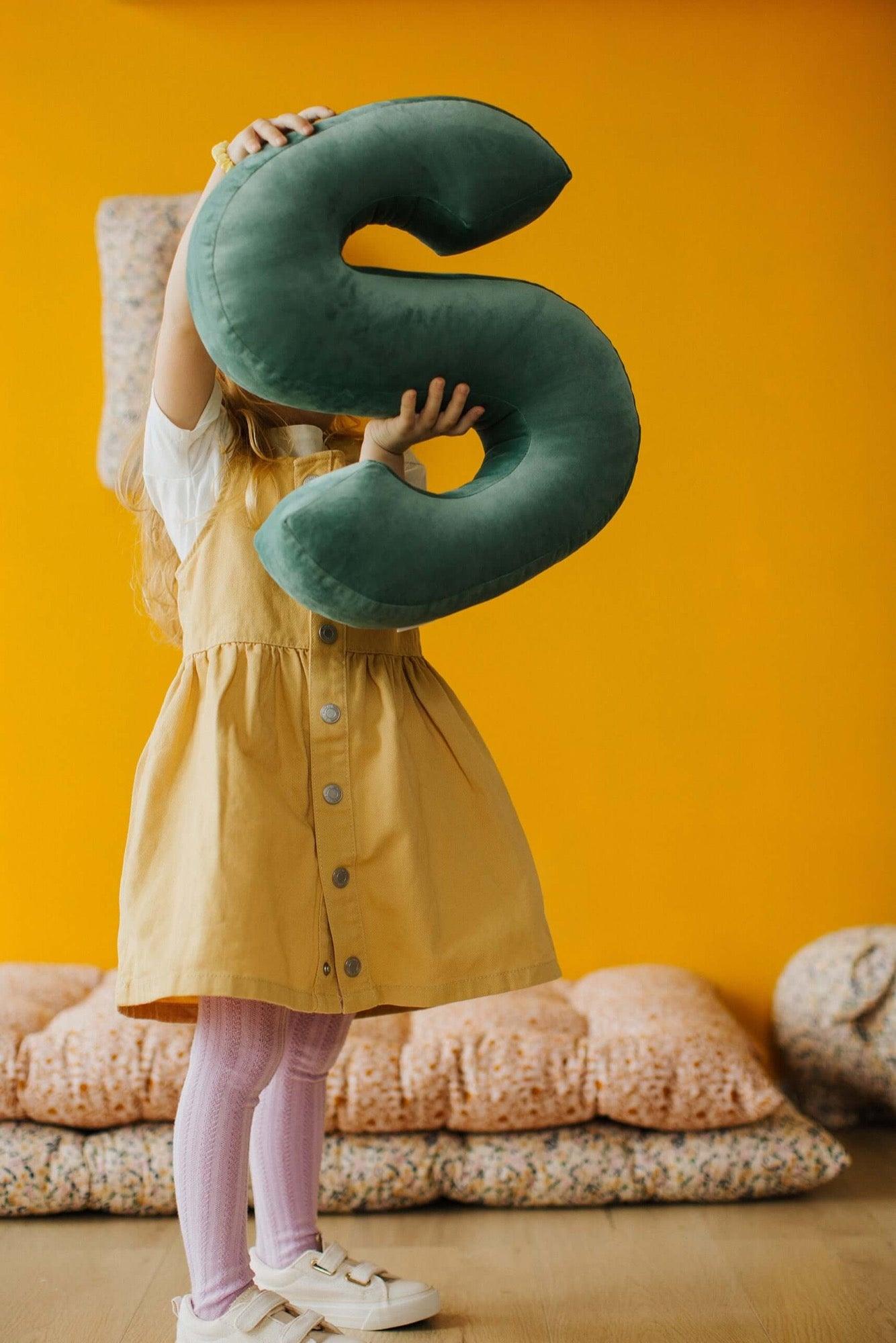 little girl keeps in hands velvet letter cushion in mint colour by bettys home