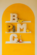 shelfs on yellow wall with velvet letter pillows by bettys home
