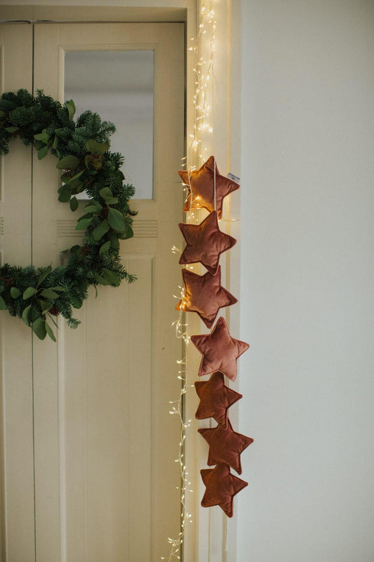 velvet star garland in pink old rose by bettys home hangs on door as christmas decoration