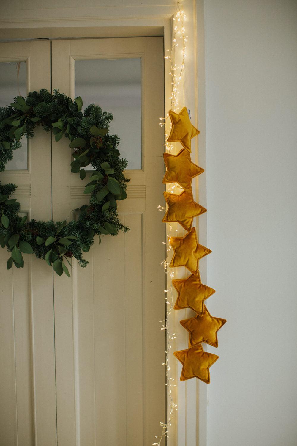 velvet star garland yellow by bettys home hanging on the door as a festive decoration