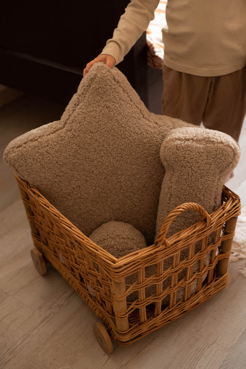 boucle star cushion mocha with boucle letter cushion in wicker cart. teddy pillow