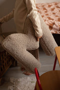 little boy standing with boucle letter cushion M mocha in hands