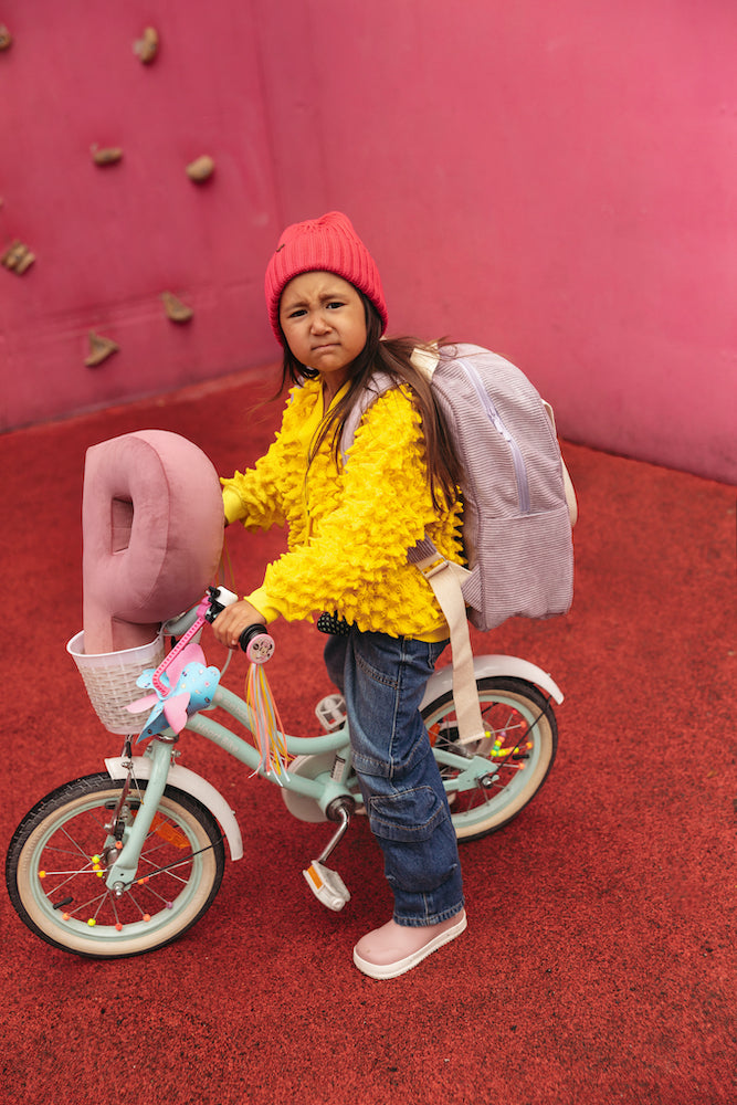 girl on bike with velvet letter cushion P in pink by bettys home. letter shaped pillows velvet