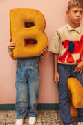 kids in school with velvet letter cushions by bettys home. velvet pillows in shape of letter