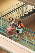two girls standing on stairs at school with velvet letter pillow and velvet star pillow by bettys home.