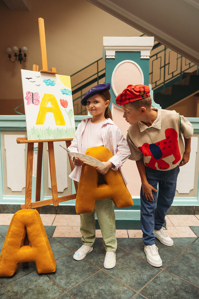 School children at play painting picture with velour letter pillow by bettys home. letter cushions in velvet