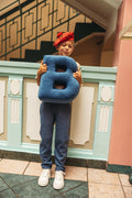 boy at school holding velvet letter cushion b by bettys home. letter shaped cushion