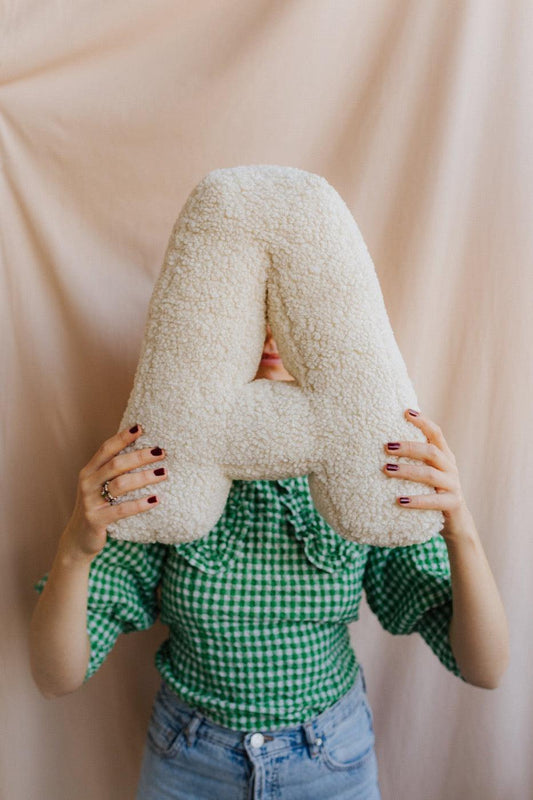 Boucle Letter cushion A by Bettys Home Teddy Letter Pillow held by woman in green checkered shirt in front of her