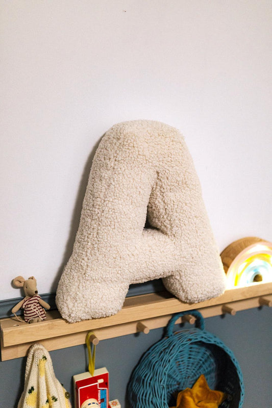 Boucle Letter Cushion A Teddy Letter Pillow by Bettys Home standing on shelf in kids room as kids room decoration 