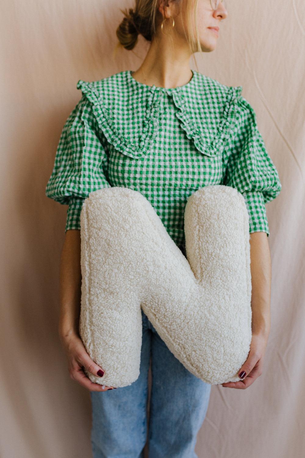 Boucle letter cushion N teddy letter pillow by bettys home held by woman in green shirt on cream background birthday gift 