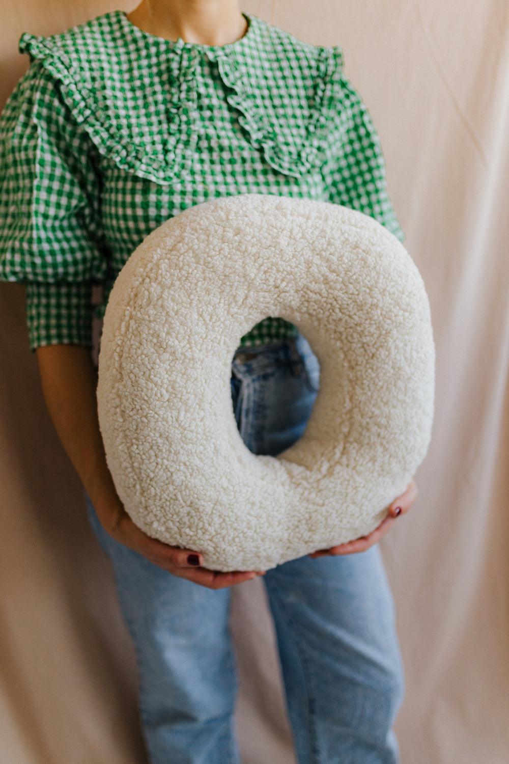 boucle letter cushion O teddy pillow by bettys home held by woman in green shirt as kindergarten gift idea