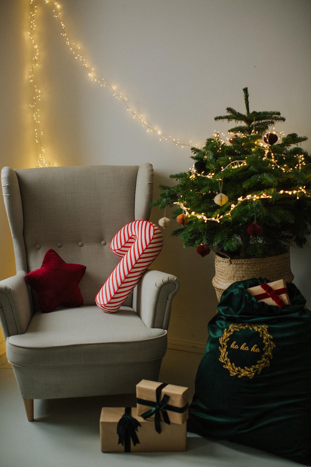 Christmas candy cane cushion red stripes by bettys home lying on an armchair next to the Christmas tree 