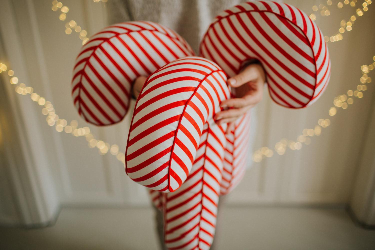 Christmas candy cane cushion red stripes by bettys home held in the hands by a woman