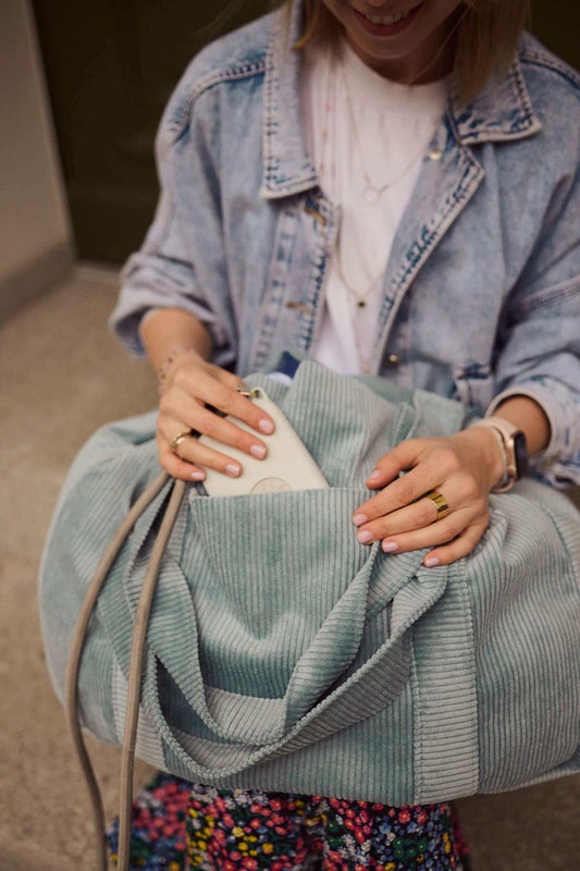 Young woman with blue corduroy shopper bag 