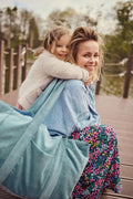Happy mom with her daughter. She has blue corduroy mom bag with her by betty's home