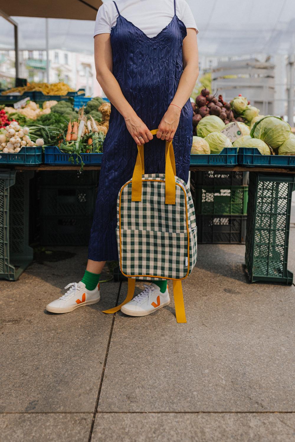 shopping woman holds in hands green gingham backpack by bettys home ideal backpack for shopping 