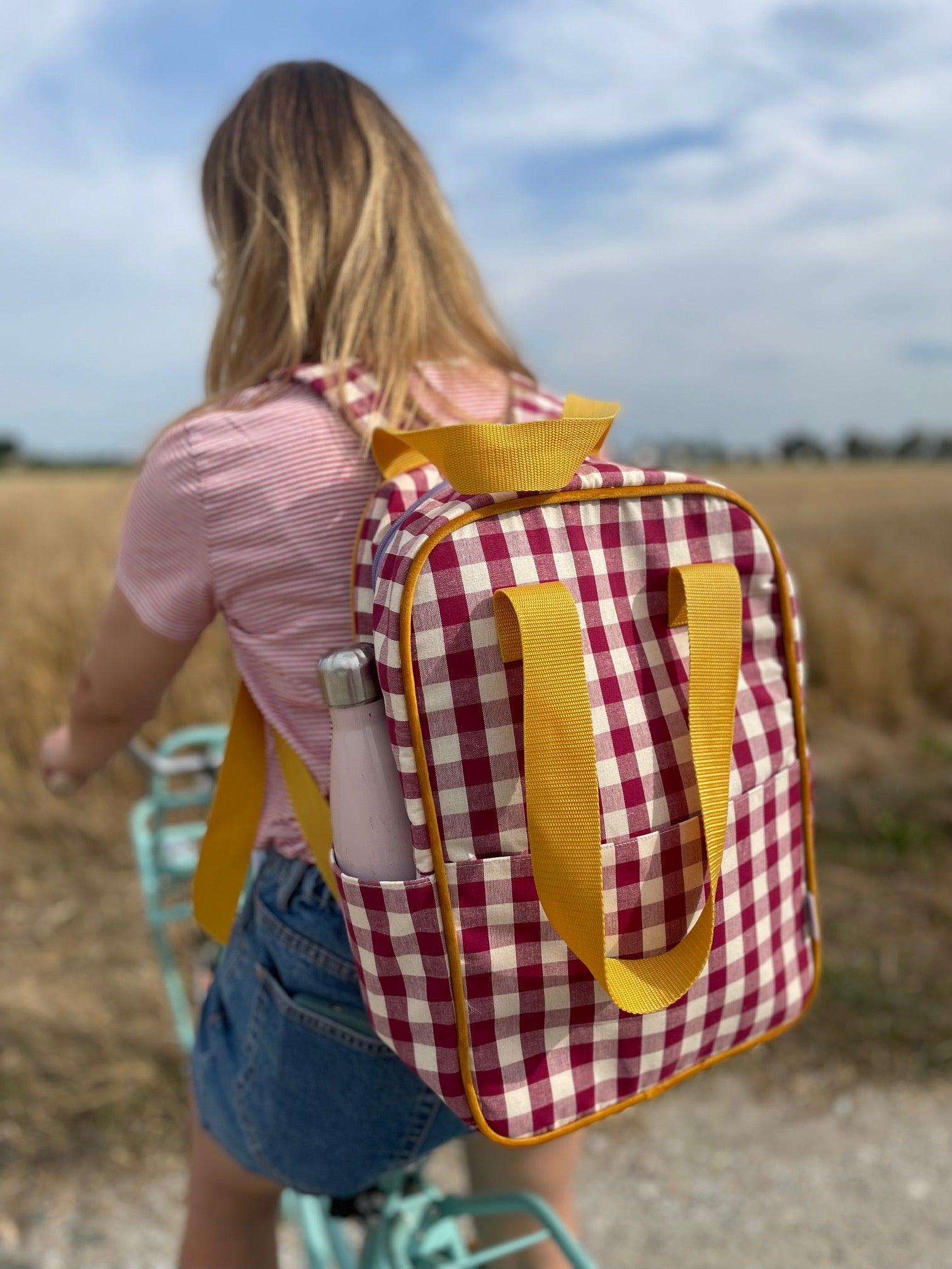 girl on mint bike with red checkered backpack by bettys home on trip on country side