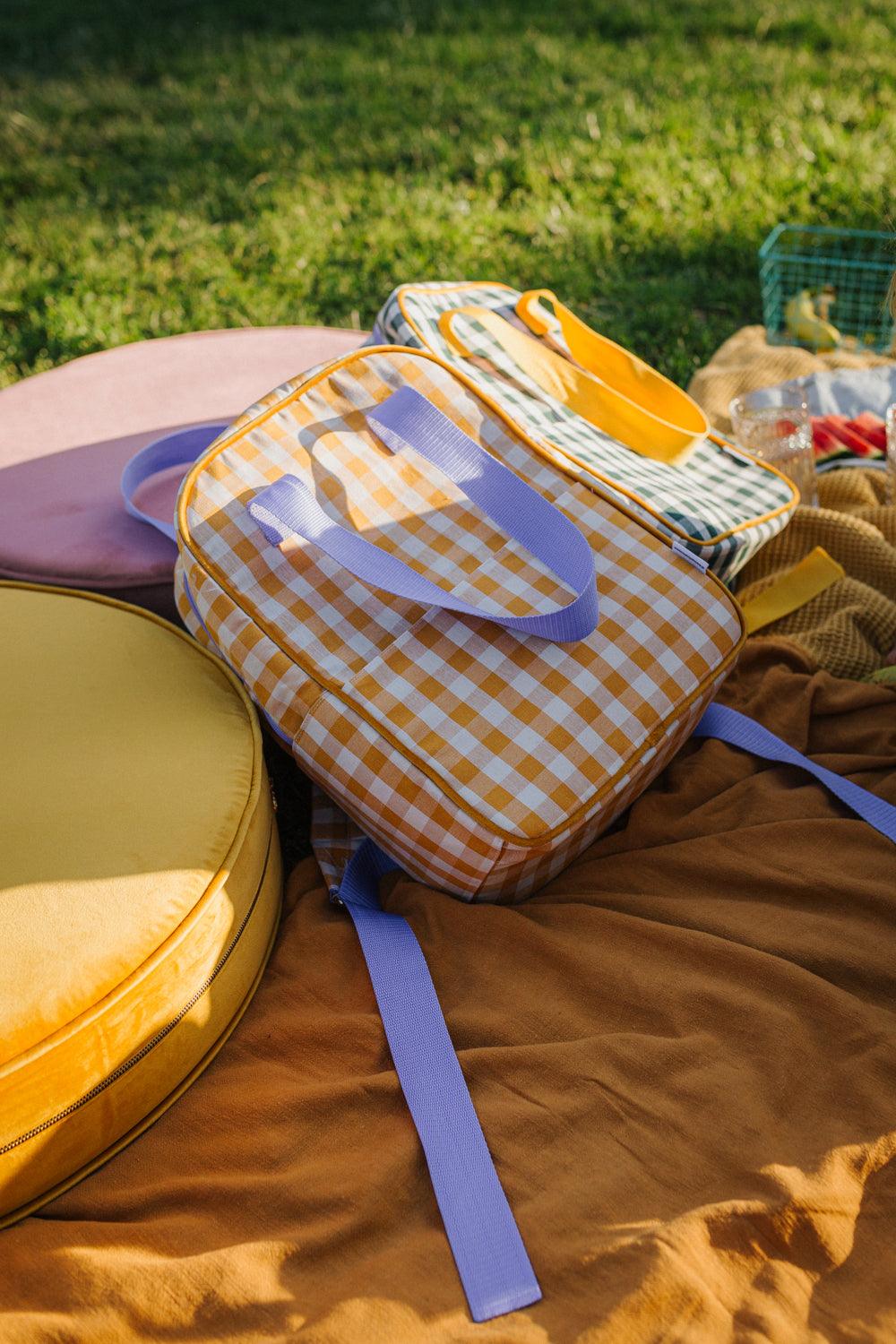yellow gingham backpack by bettys home who lies on a picnic on a large velvet pouf by bettys home