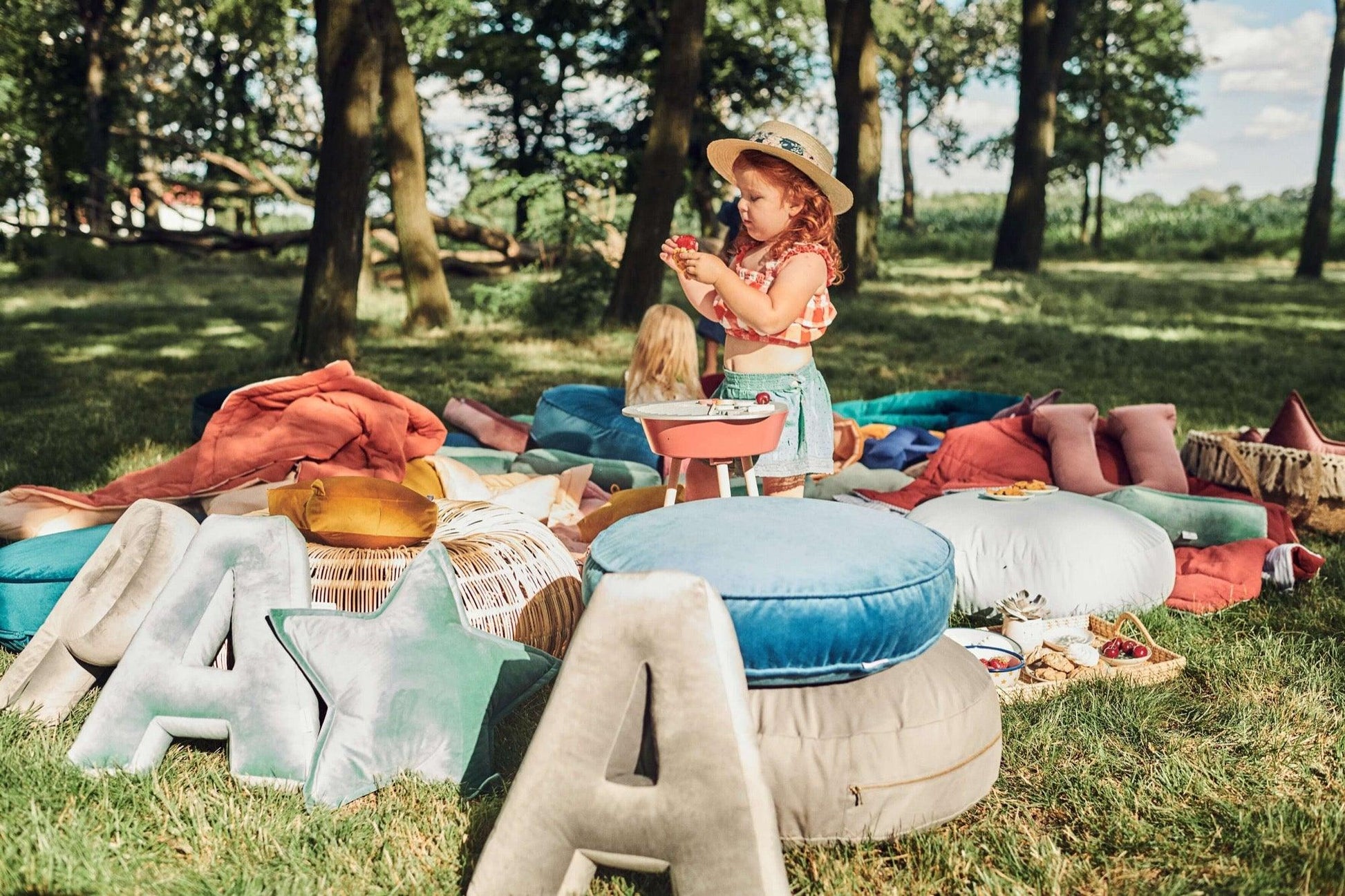 pillows letter shaped by betty's home with little girl playing in garden 