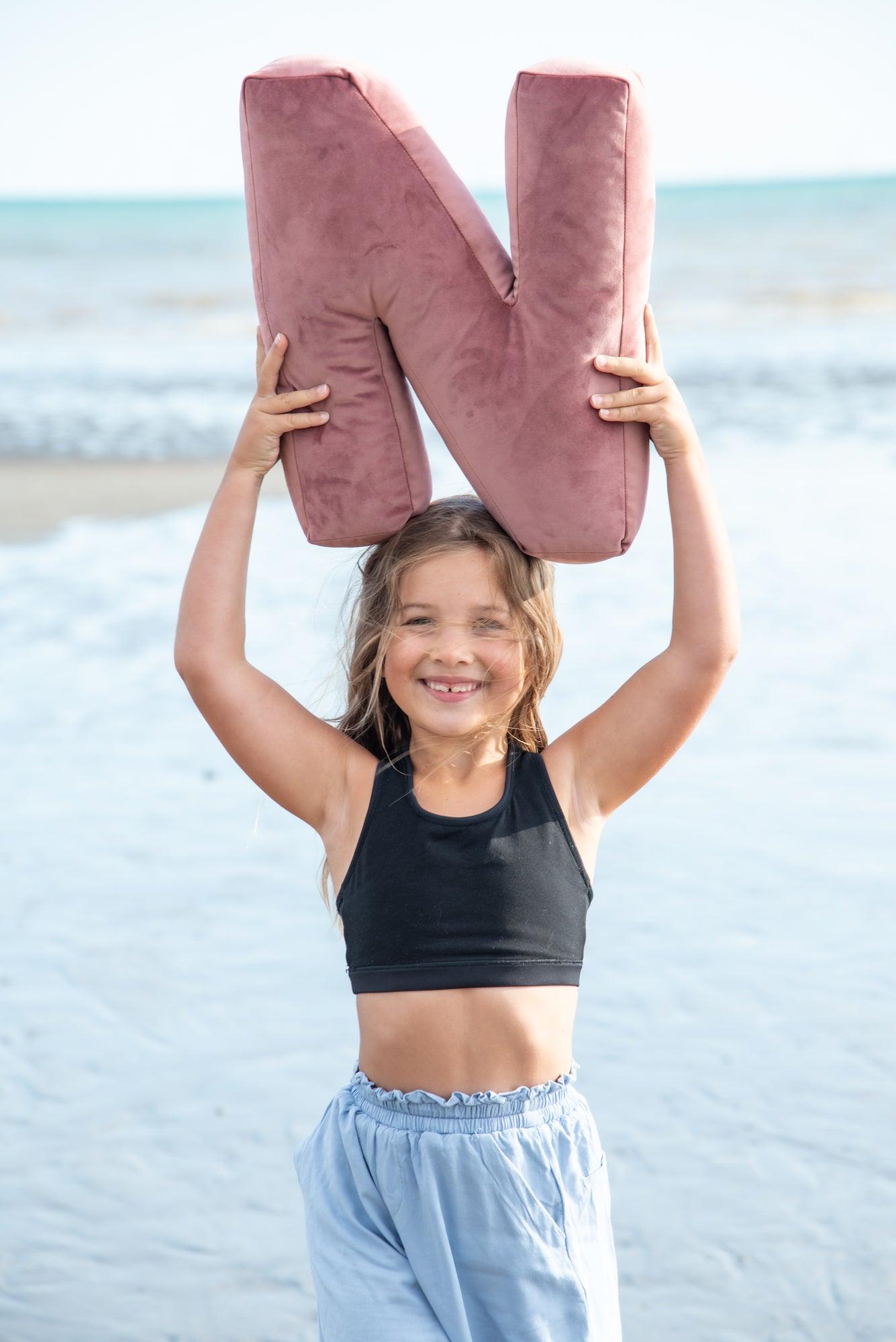 cute girl with velvet letter n pink by bettys home held above the head