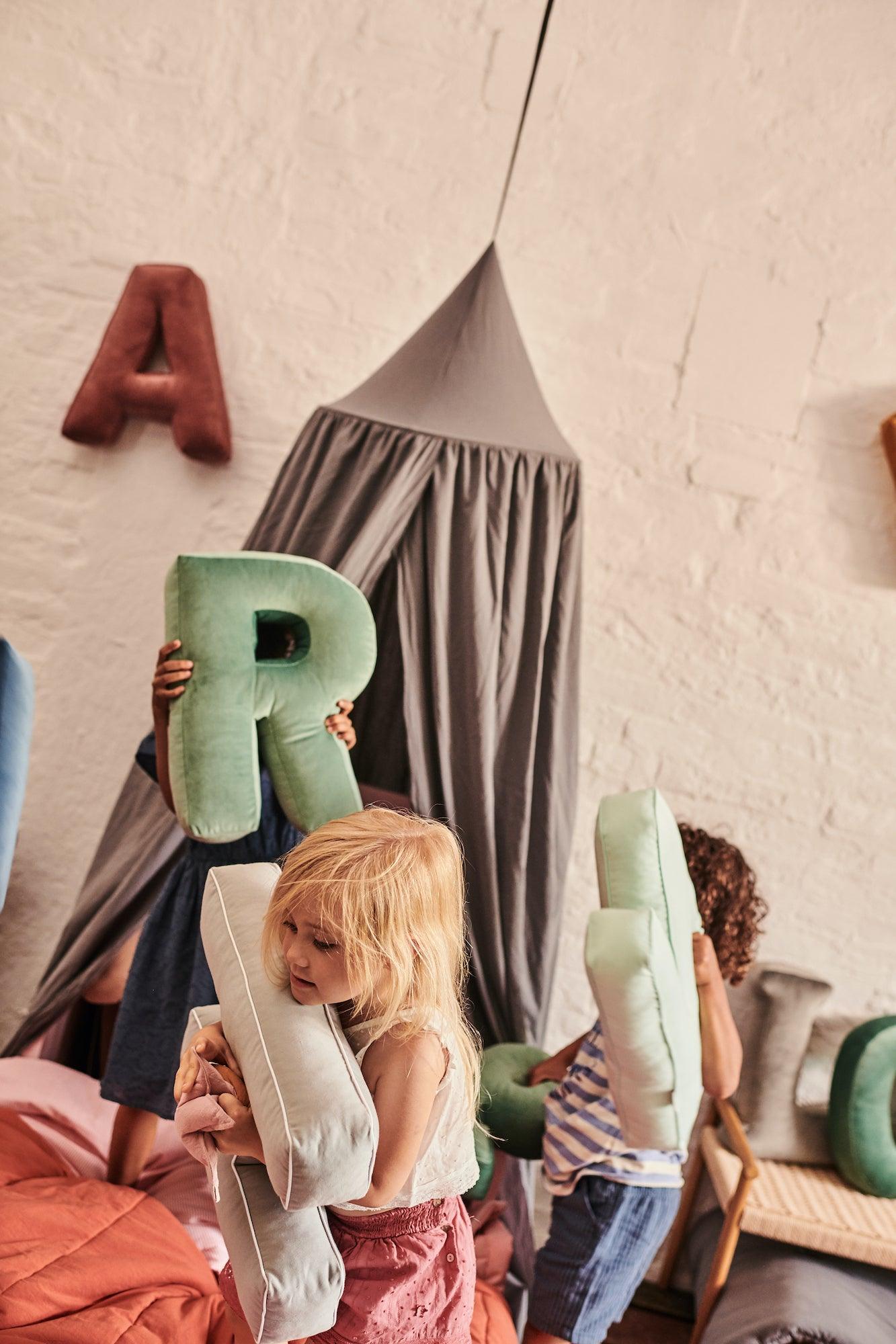 kids playing in kindergarten with letter pillows by bettys home and canopy over the bed by bettys home