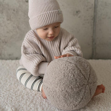 baby boy playing with taupe boucle ball cushion by bettys home. Ball shaped pillow