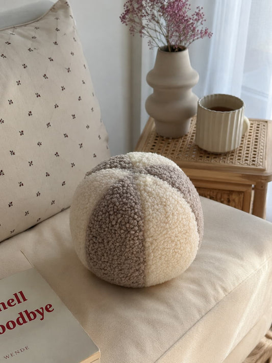 boucle ball cushion mixed colour mocha and cream by bettys home on chair in living room