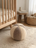 boucle ball cushion mixed colour mocha and cream by bettys home  next to kids crib