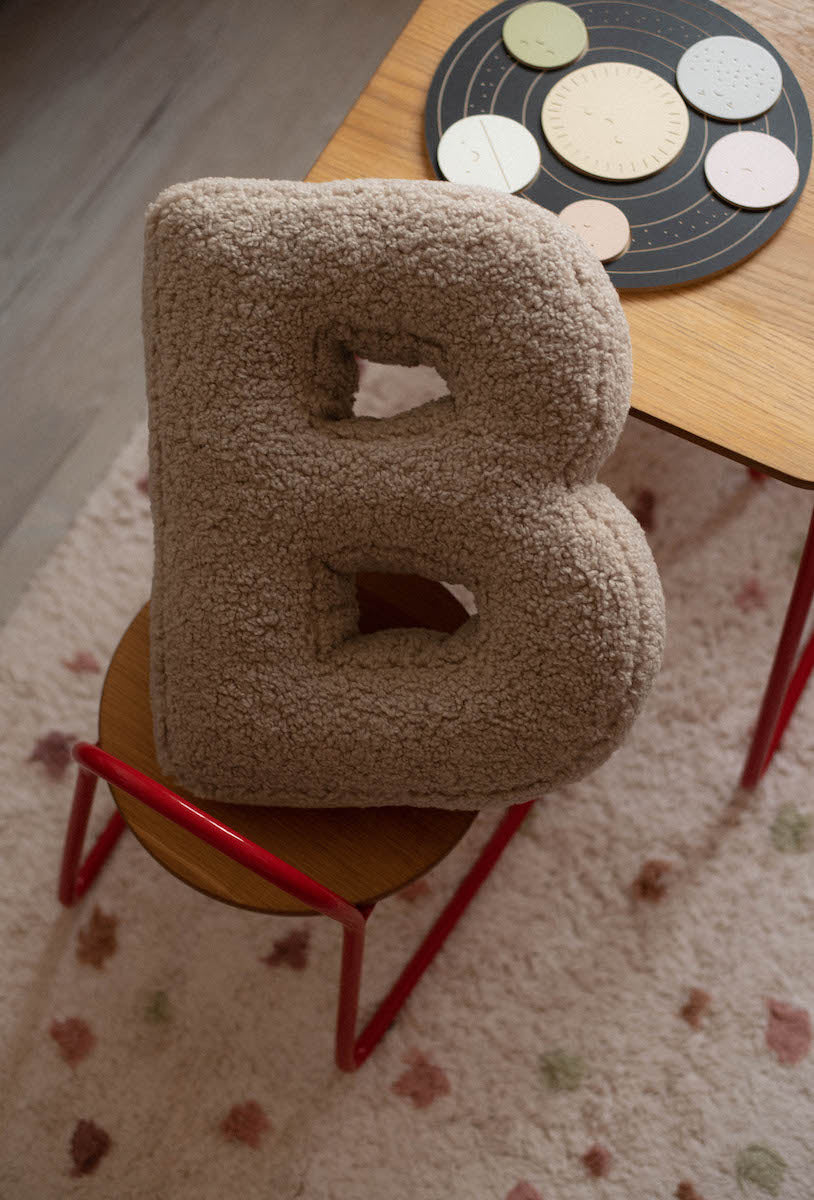 boucle letter cushion b on kids chair. teddy pillow 