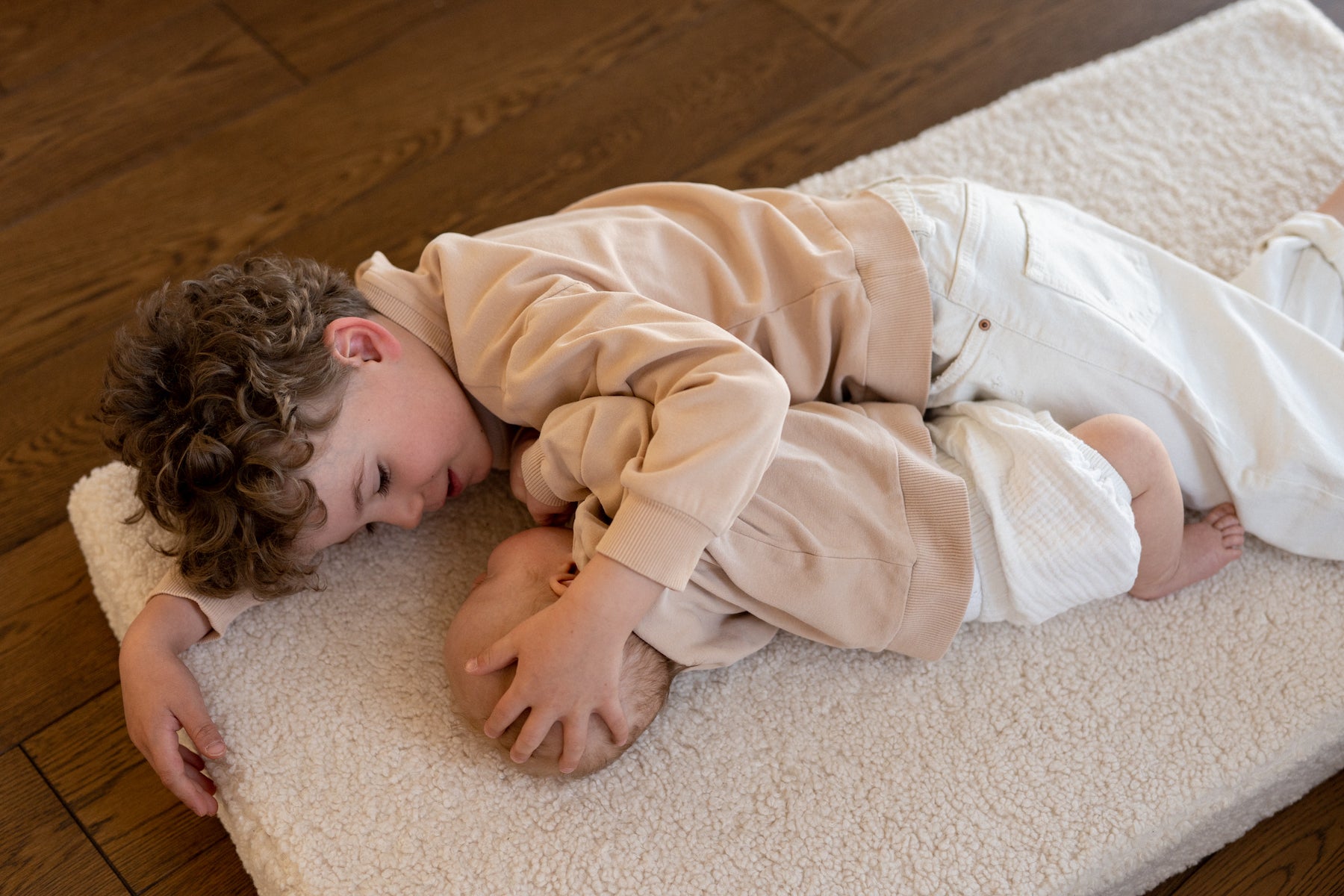 two brothers on boucle mattress by bettys home lying on floor 