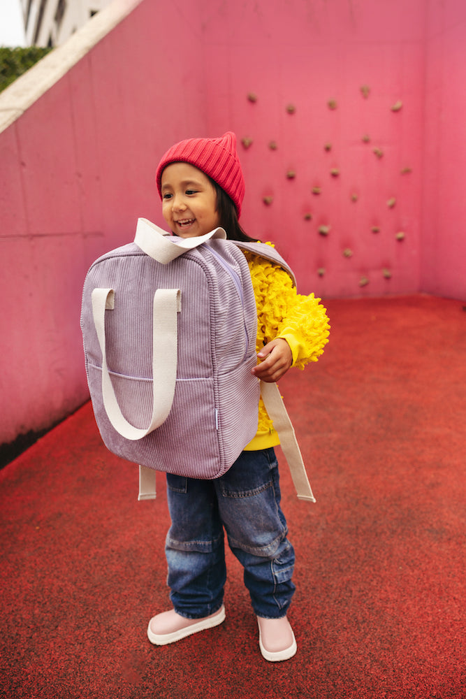 little girl on playground with corduroy backpack in lilac by bettys home