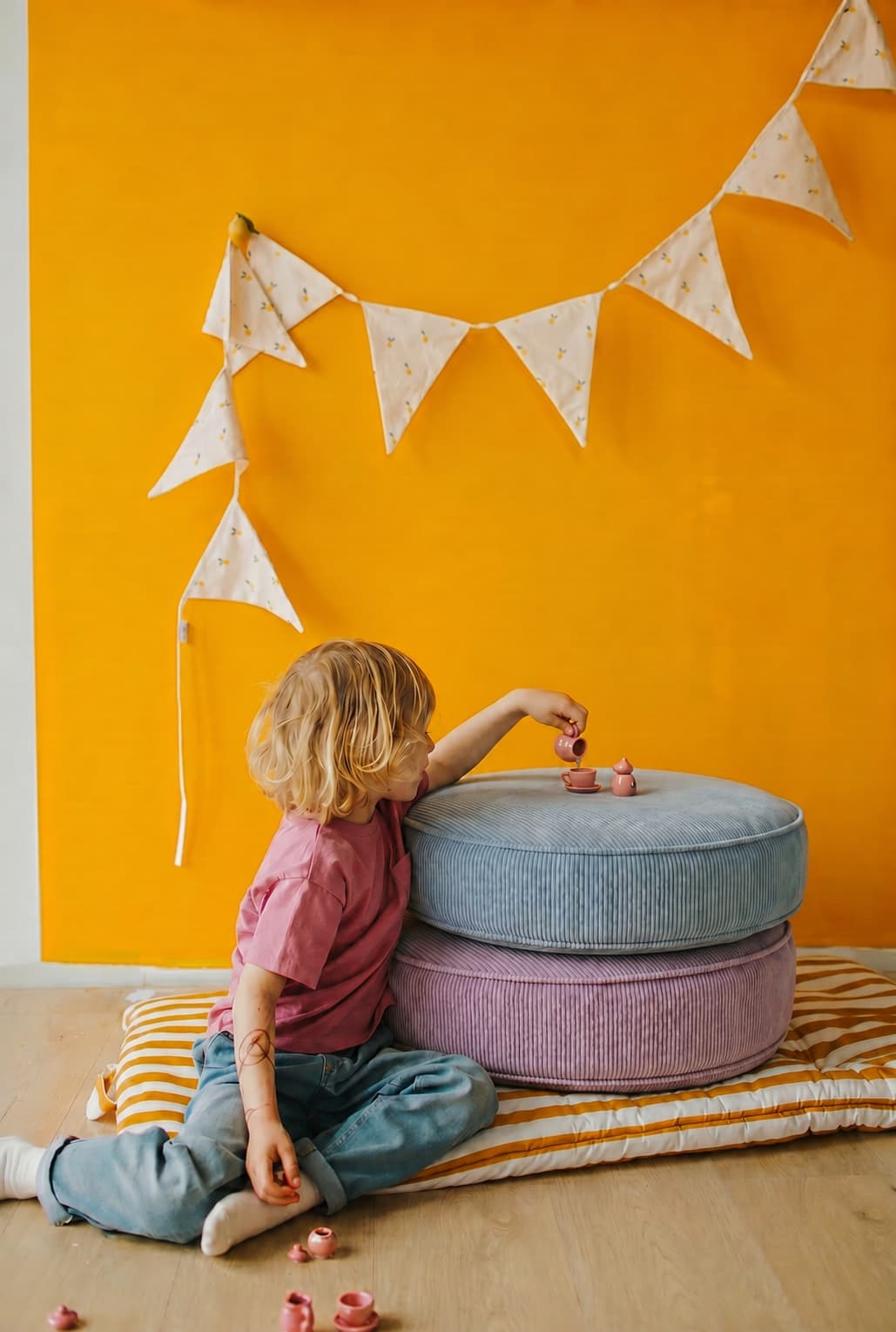 child playing next to corduroy floor poufs by Bettys home