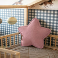 Pink corduroy star cushion styled in oval wooden crib against concrete wall by Bettys Home
