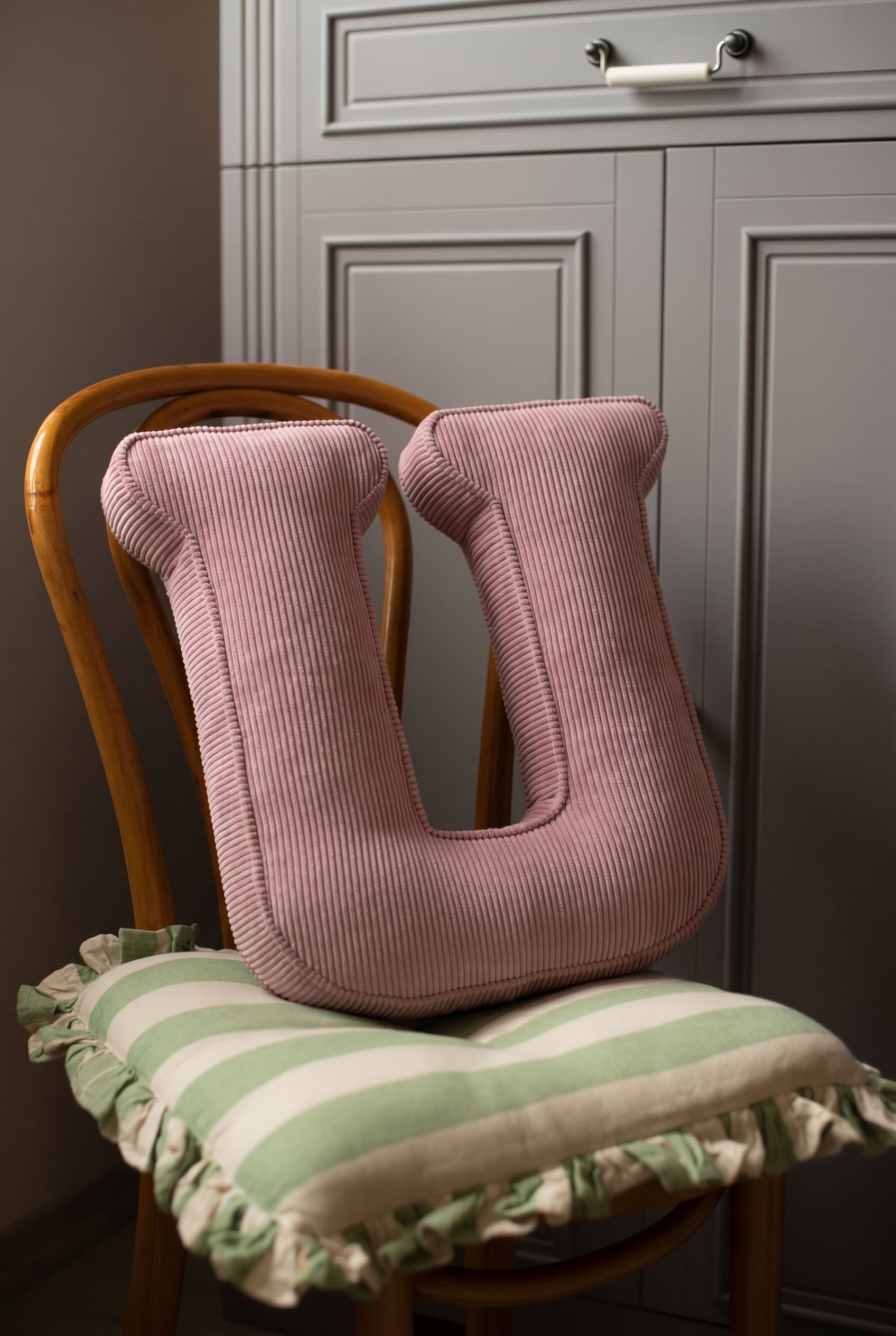 corduroy letter cushion U by bettys home in kids room on chair. Cushion in shape of letter