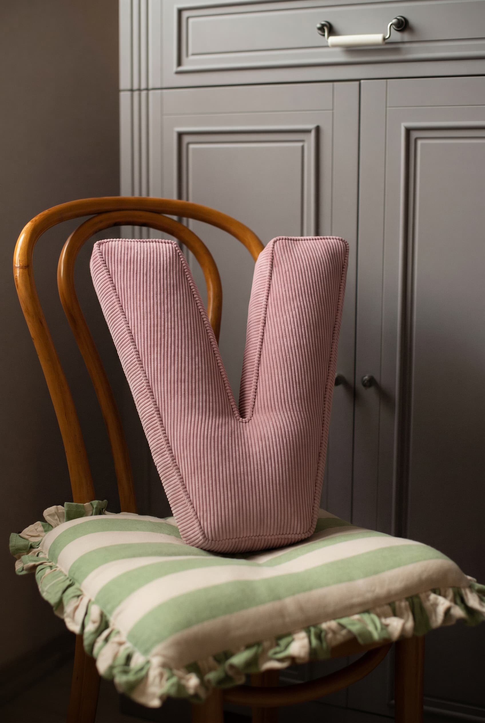 corduroy letter cushion V by bettys home in kids room on chair. Cushion in shape of letter