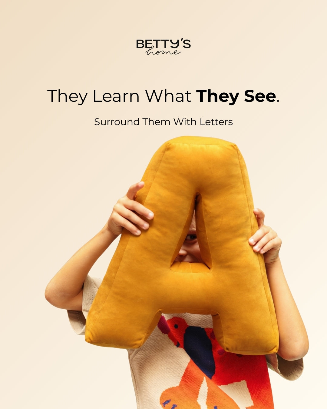 a boy holding letter cushion by Bettys home