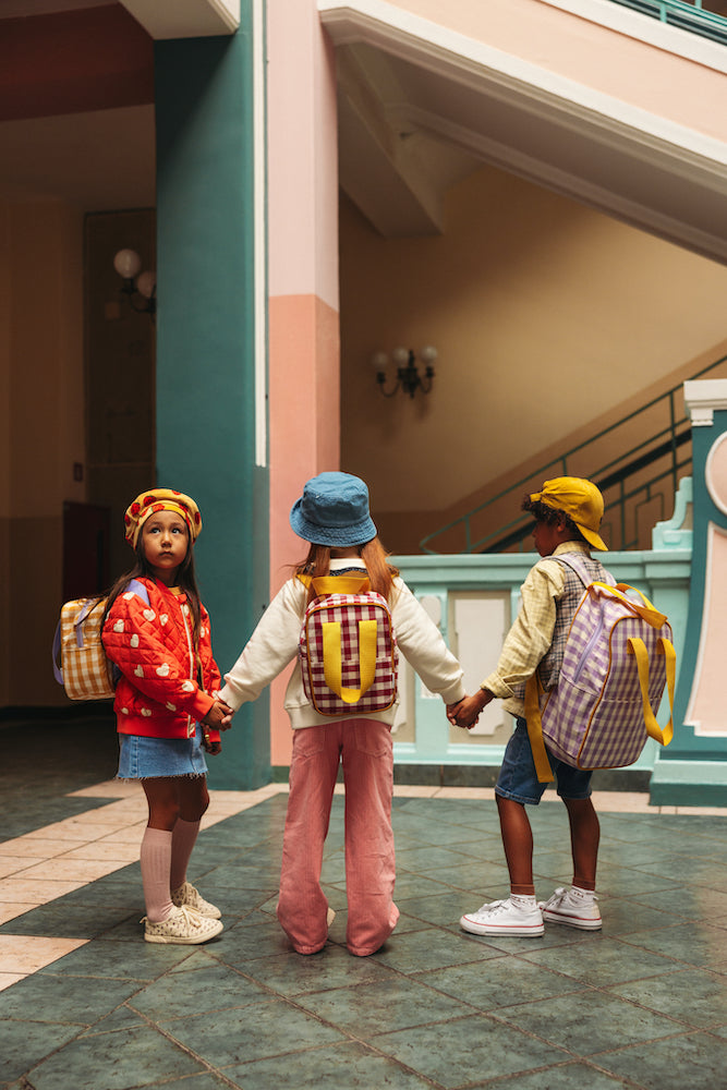 Children in the school corridor with gingham backpacks by bettys home. 