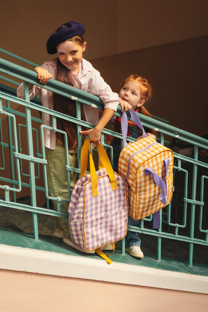 girls standing on steps at school with gingham backpacks by bettys home.