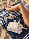 Lemon Ruffle Makeup Bag by Bettys home lying on towel on beach 