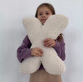 Little girl holding boucle letter cushion X in creme by bettys home