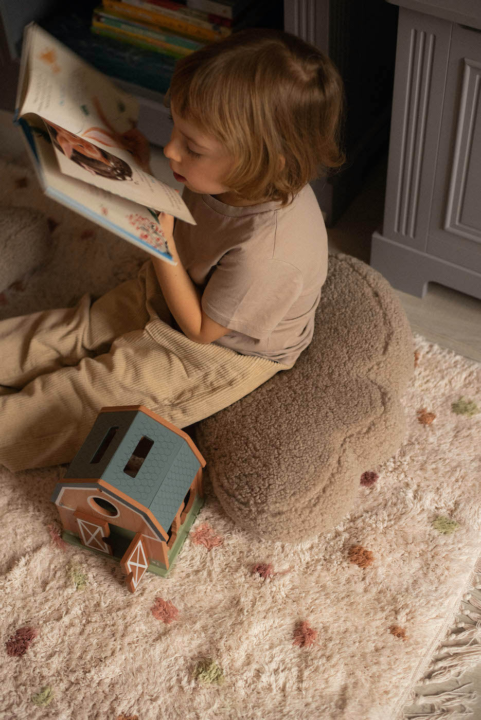 boy sitting on boucle cloud cushion by bettys home. deco pillow kids gift idea. kids room decoration